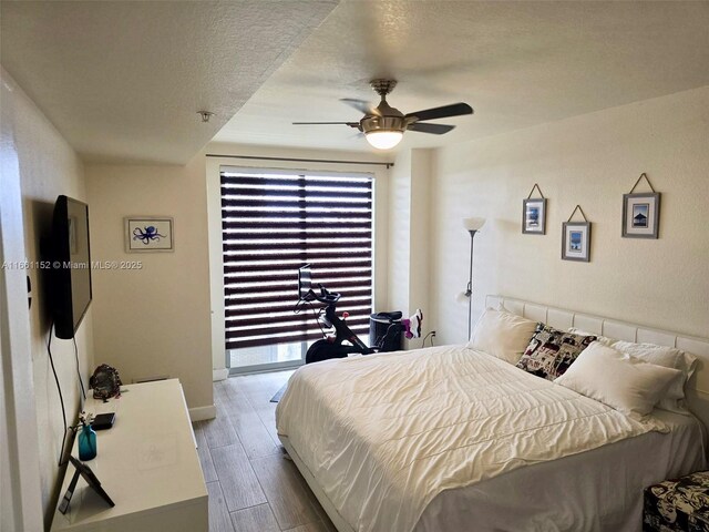 bedroom with access to outside, ceiling fan, and a textured ceiling