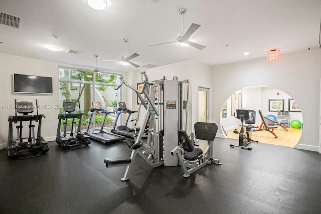 exercise room with floor to ceiling windows and ceiling fan