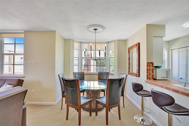 dining area with light colored carpet, a textured ceiling, and a wealth of natural light