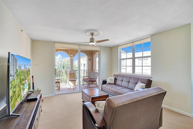 carpeted living room with a textured ceiling and ceiling fan