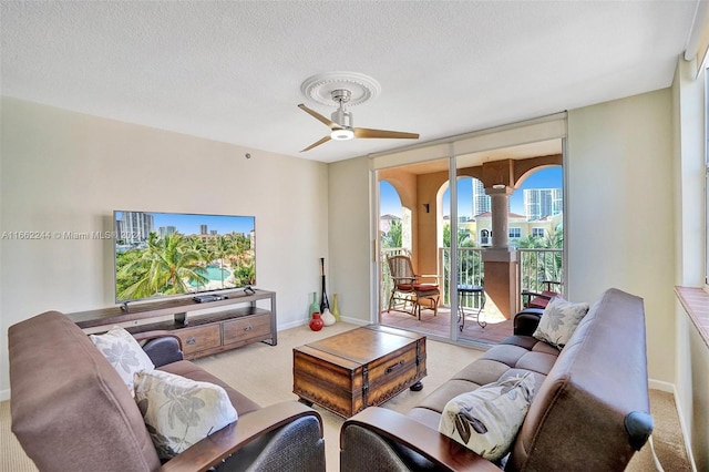 carpeted living room with a textured ceiling and ceiling fan