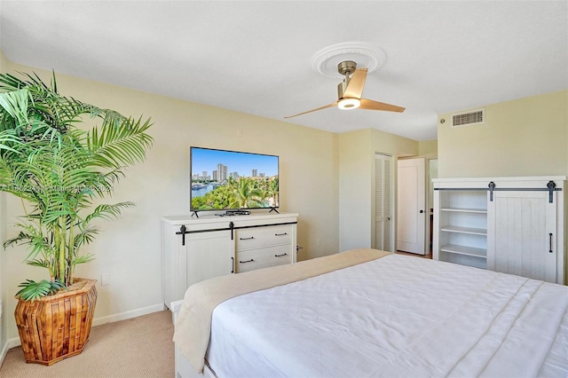 bedroom with ceiling fan, light colored carpet, and a closet