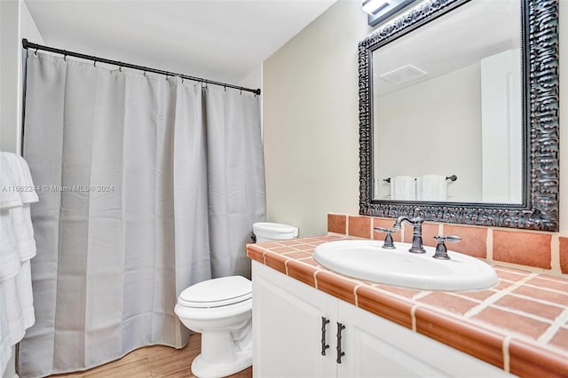 bathroom with curtained shower, wood-type flooring, vanity, and toilet