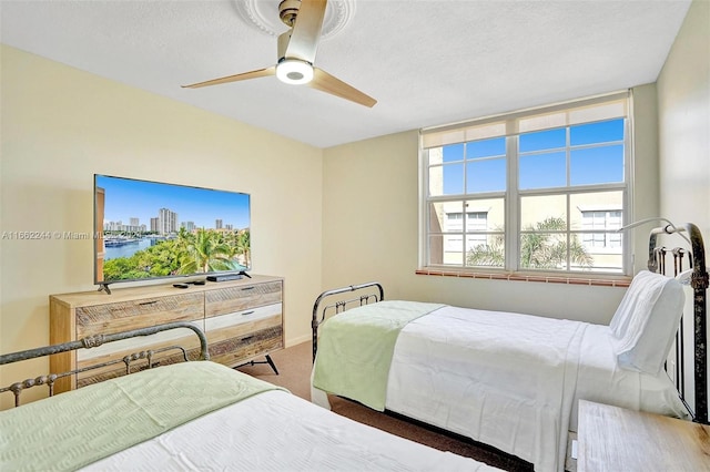 bedroom featuring a textured ceiling, carpet flooring, and ceiling fan