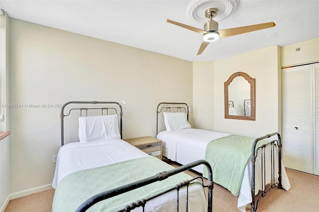 bedroom featuring a closet, ceiling fan, and light colored carpet