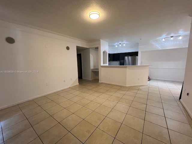 unfurnished living room with a textured ceiling and light tile patterned flooring