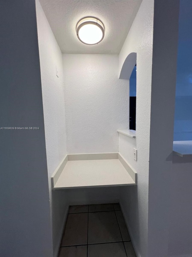 bathroom featuring tile patterned flooring and a textured ceiling