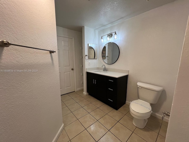 bathroom featuring a textured ceiling, tile patterned flooring, vanity, and toilet