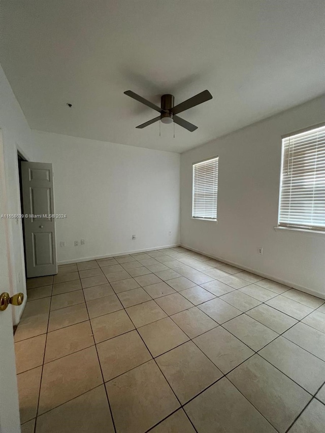 spare room featuring ceiling fan and light tile patterned floors