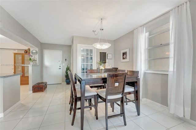 dining room with a chandelier and light tile patterned floors