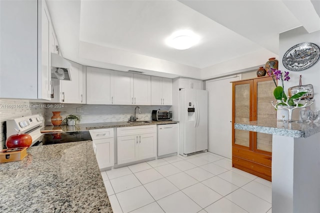 kitchen with decorative backsplash, white appliances, sink, light tile patterned floors, and white cabinets