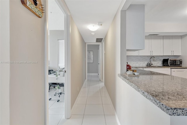 hallway featuring light tile patterned floors and sink