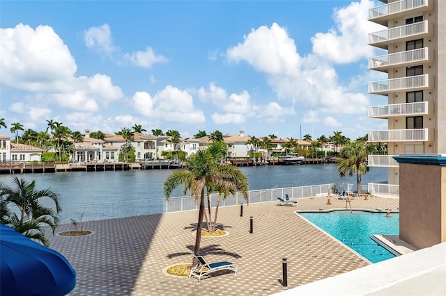 view of pool featuring a water view and a patio