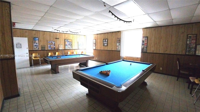 playroom with a paneled ceiling, wood walls, and pool table