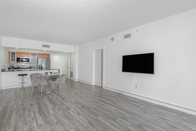 living room featuring a textured ceiling and light wood-type flooring