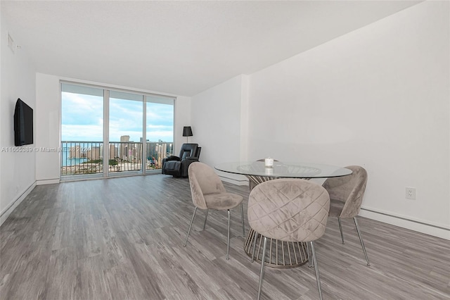 dining area with hardwood / wood-style flooring and a wall of windows