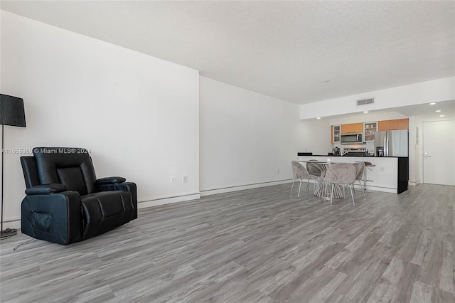 living room featuring a textured ceiling and light wood-type flooring