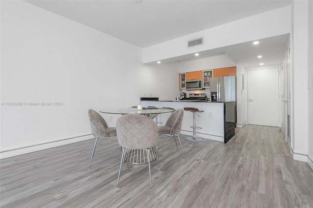 dining space with light hardwood / wood-style floors