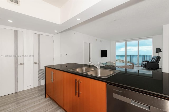 kitchen featuring light wood-type flooring, a water view, stainless steel dishwasher, and sink