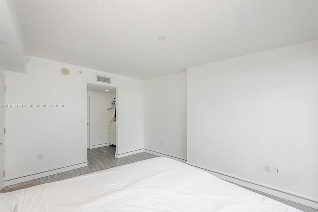 unfurnished room featuring light hardwood / wood-style floors and a textured ceiling