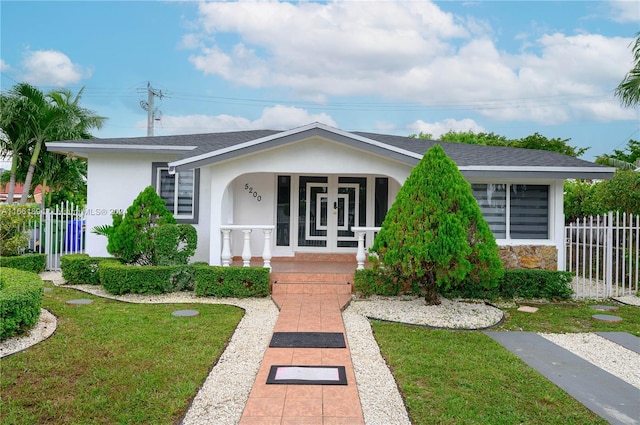 ranch-style home with a front yard and covered porch