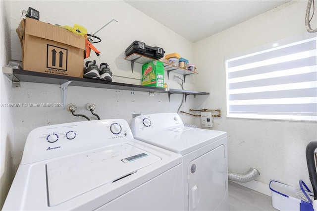 laundry area with light wood-type flooring, a textured ceiling, and independent washer and dryer