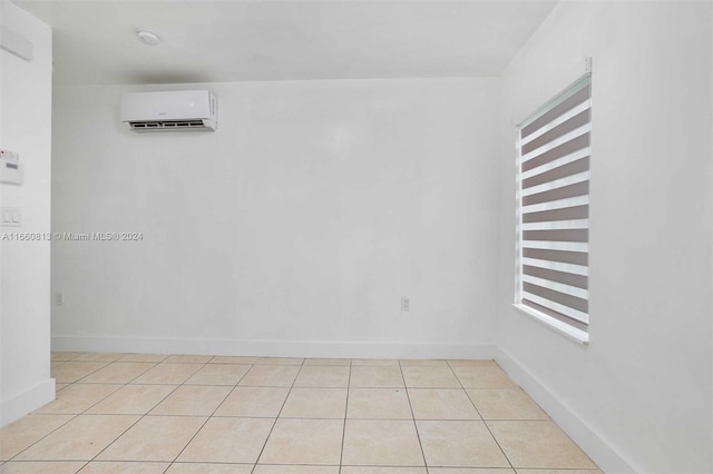 spare room featuring light tile patterned floors and a wall mounted air conditioner