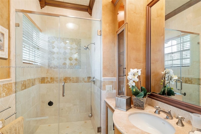 bathroom with a shower with door, ornamental molding, and vanity