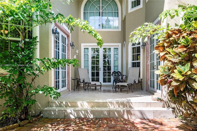 view of exterior entry with french doors and a patio area