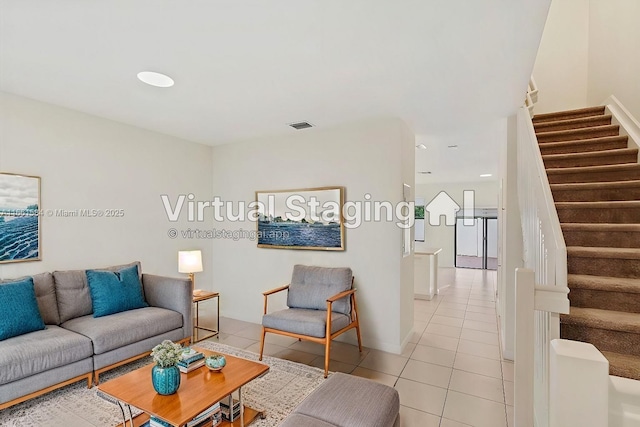 living room featuring light tile patterned floors, visible vents, and stairs