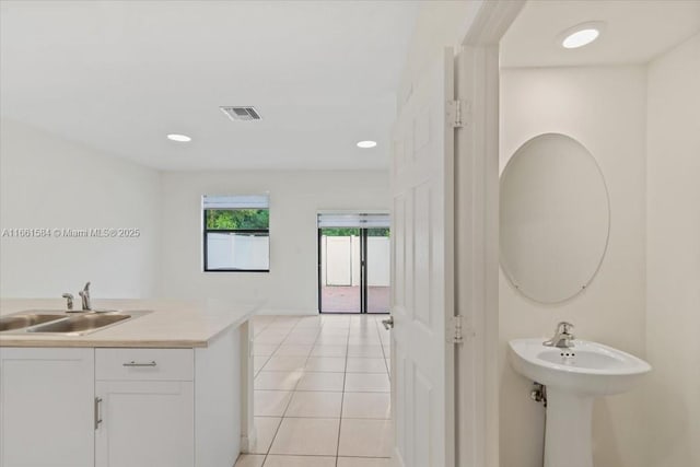 kitchen with white cabinetry, sink, and light tile patterned floors