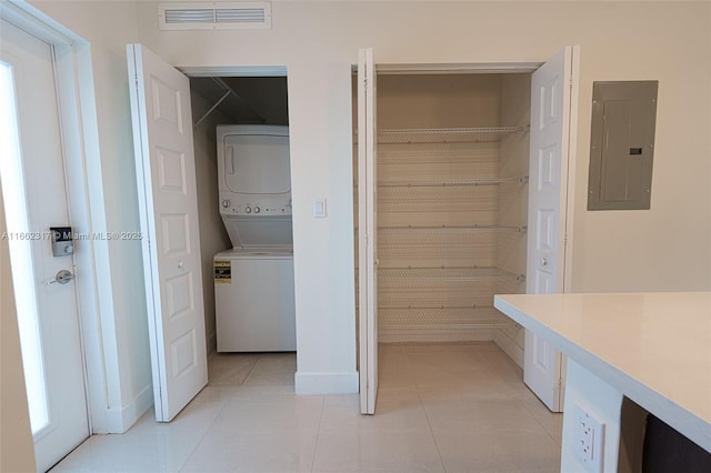 pantry featuring stacked washer / drying machine and electric panel