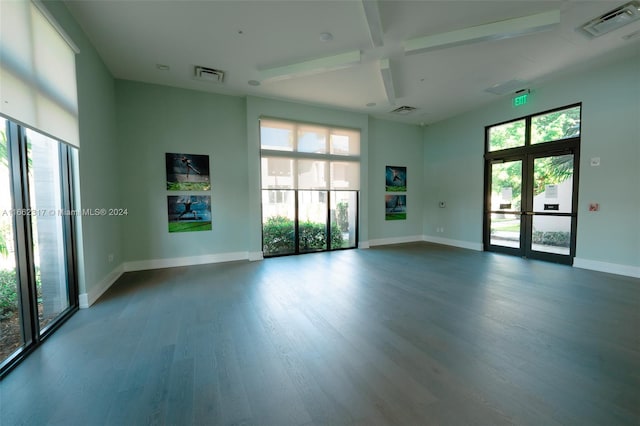 unfurnished room with wood-type flooring, beamed ceiling, and french doors