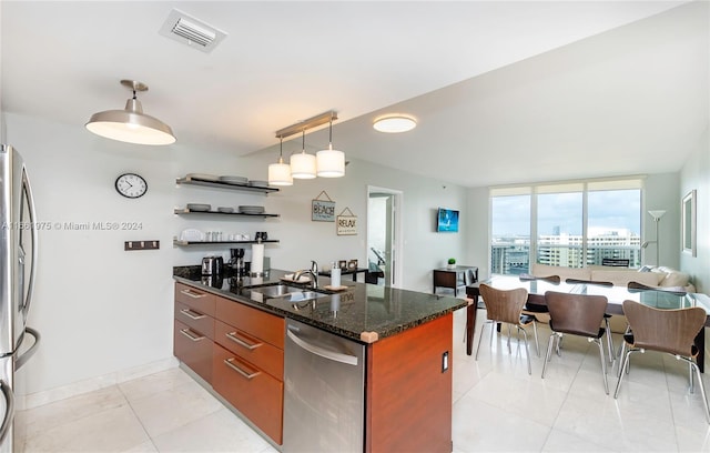 kitchen featuring light tile patterned floors, stainless steel appliances, decorative light fixtures, dark stone counters, and sink