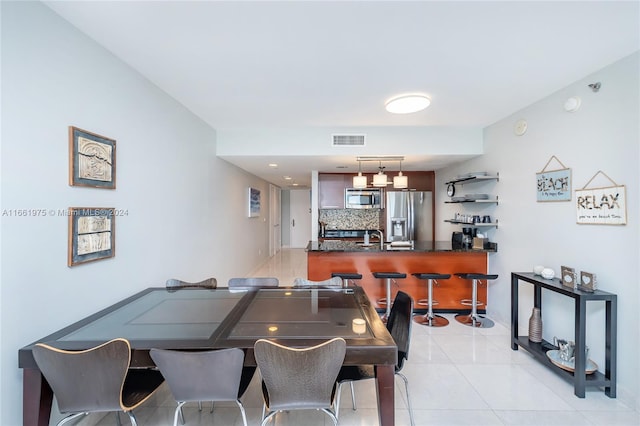 dining room with indoor wet bar and light tile patterned flooring