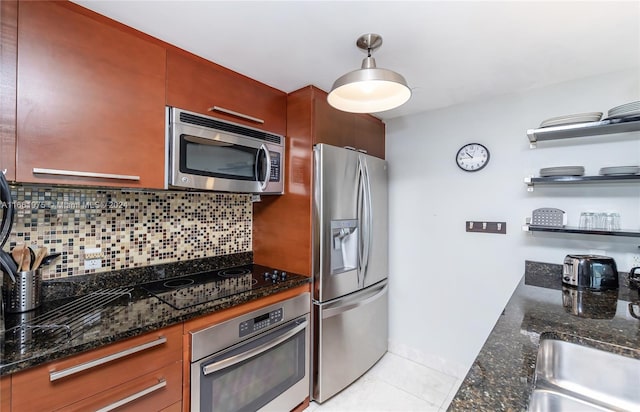 kitchen with pendant lighting, appliances with stainless steel finishes, tasteful backsplash, and dark stone counters