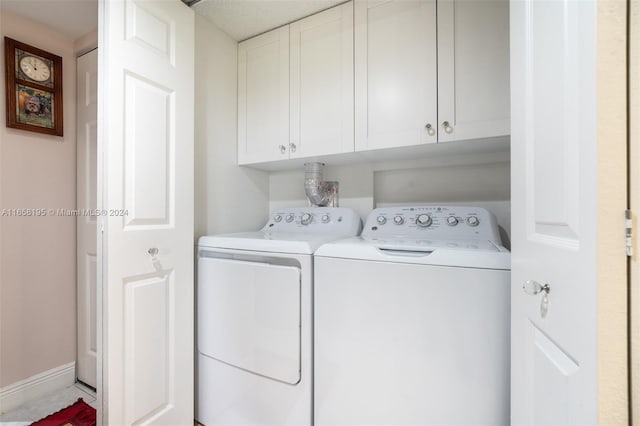 washroom featuring washer and clothes dryer and cabinets