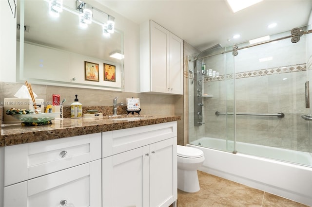 full bathroom featuring backsplash, vanity, tile patterned flooring, bath / shower combo with glass door, and toilet