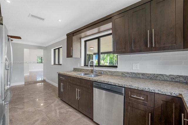 kitchen featuring light stone counters, visible vents, appliances with stainless steel finishes, ornamental molding, and a sink