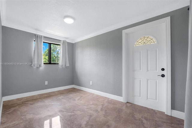 empty room featuring ornamental molding and baseboards