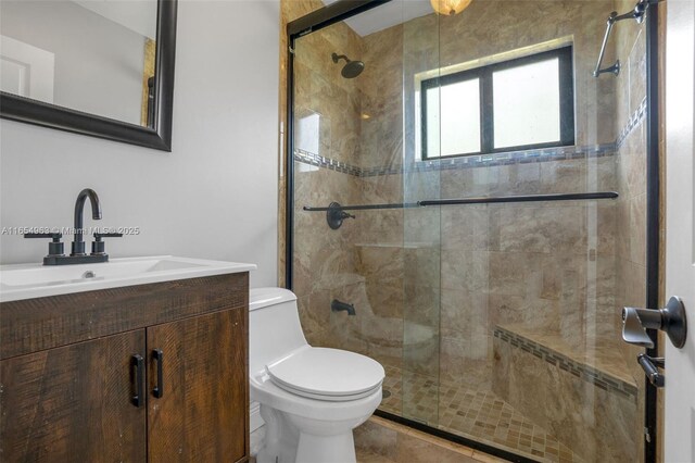 bathroom featuring tile patterned floors, toilet, vanity, and walk in shower