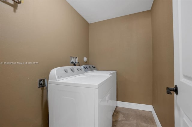 washroom with laundry area, separate washer and dryer, and baseboards