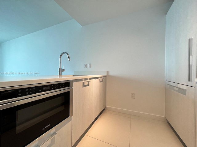 kitchen with oven, light tile patterned flooring, sink, and white refrigerator