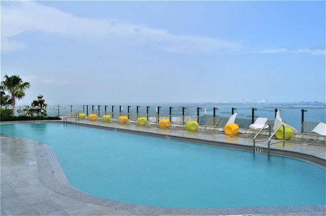 view of pool with a patio and a water view