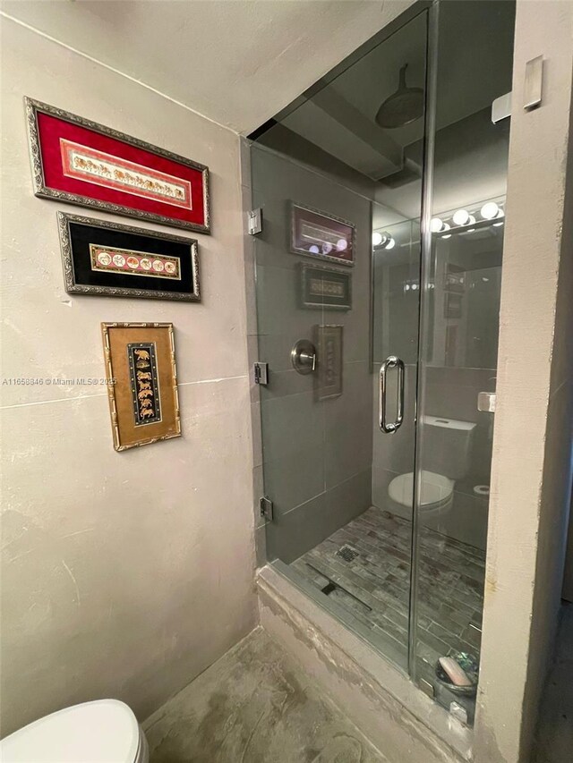 bathroom featuring an enclosed shower and toilet