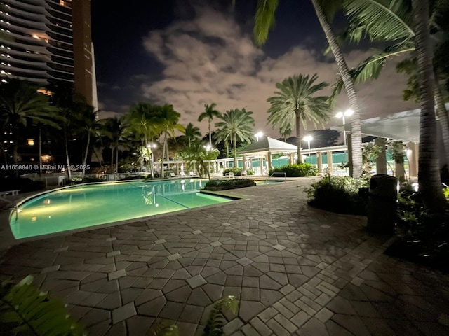 pool at twilight featuring a patio area