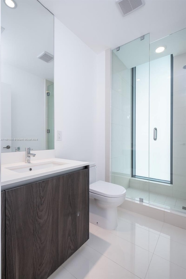 bathroom featuring vanity, toilet, tile patterned floors, and an enclosed shower