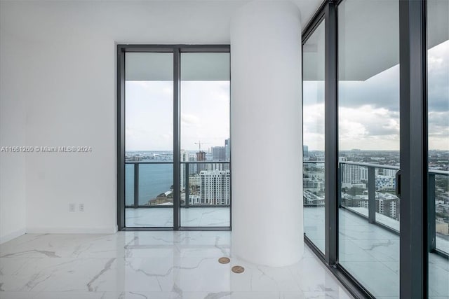 unfurnished room featuring a water view and floor to ceiling windows