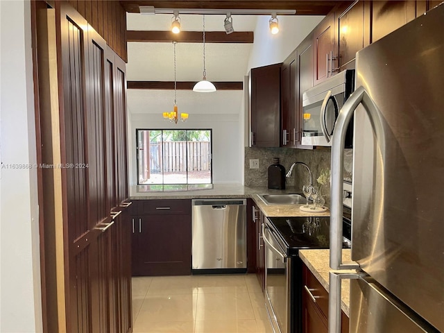 kitchen with appliances with stainless steel finishes, hanging light fixtures, light tile patterned floors, track lighting, and sink