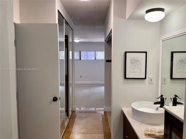 bathroom featuring tile patterned floors, a textured ceiling, and vanity